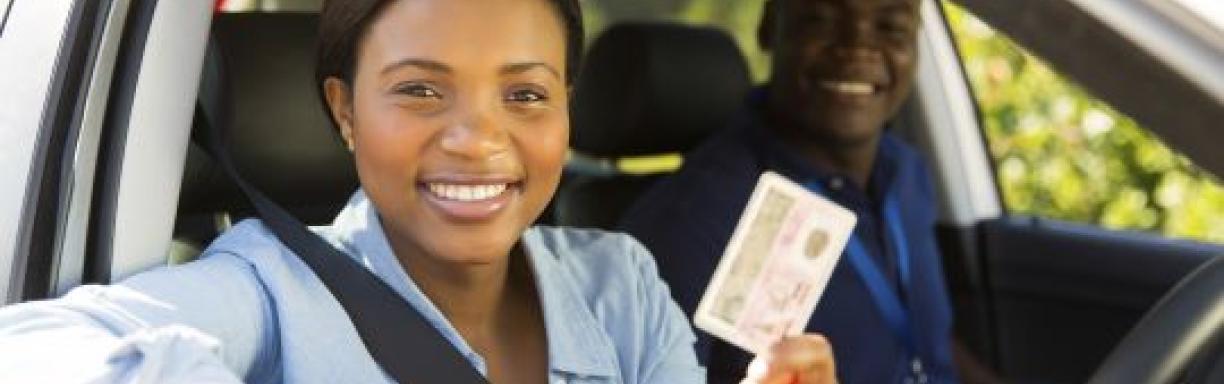 A young woman showing off her driving licence